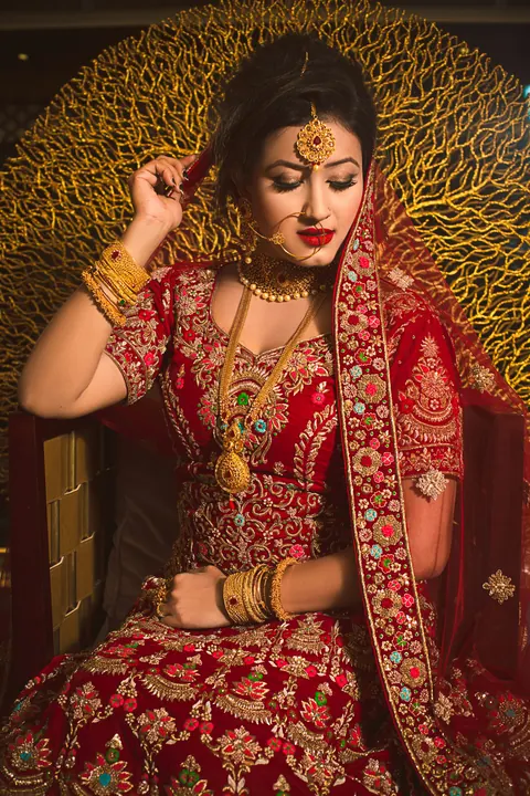 A bride seated against a gold backdrop
