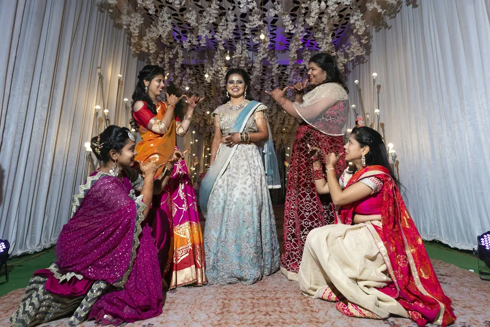 A group of women in red and gold saris at a celebration