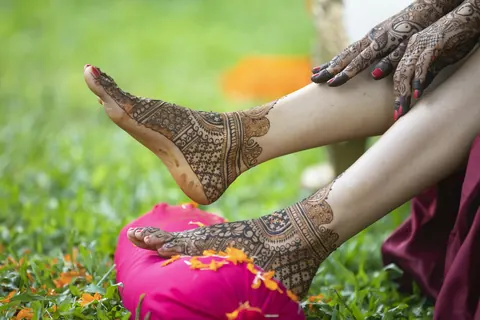 Hennaed feet on a pink cushion