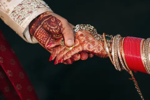 Two hennaed hands holding each other