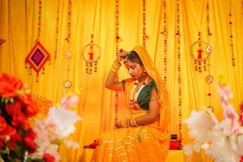 A bride in yellow seated on a decorated swing