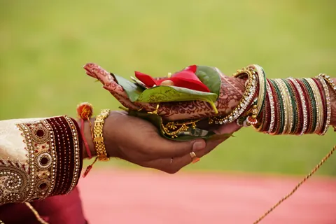 Hands with bangles holding ritual offerings